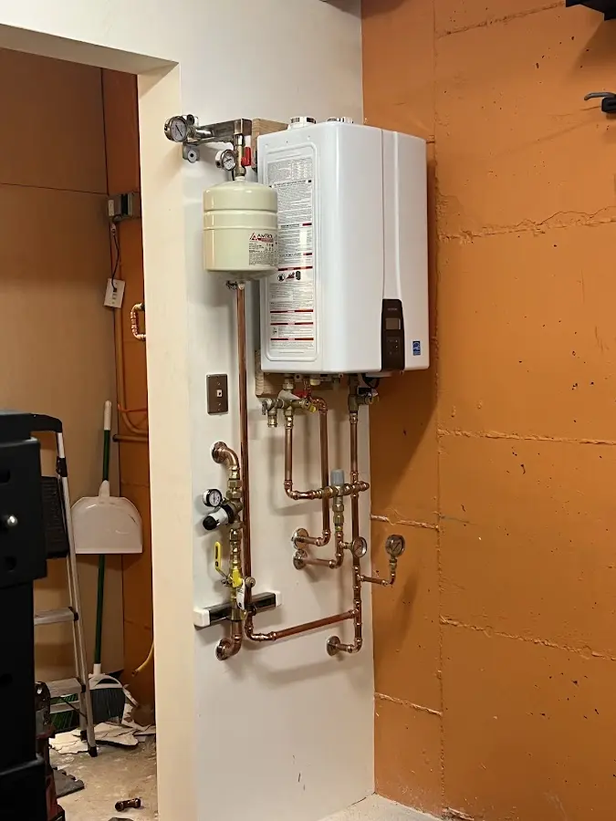 Plumbing technician inspecting water heater connections in Richmond Heights